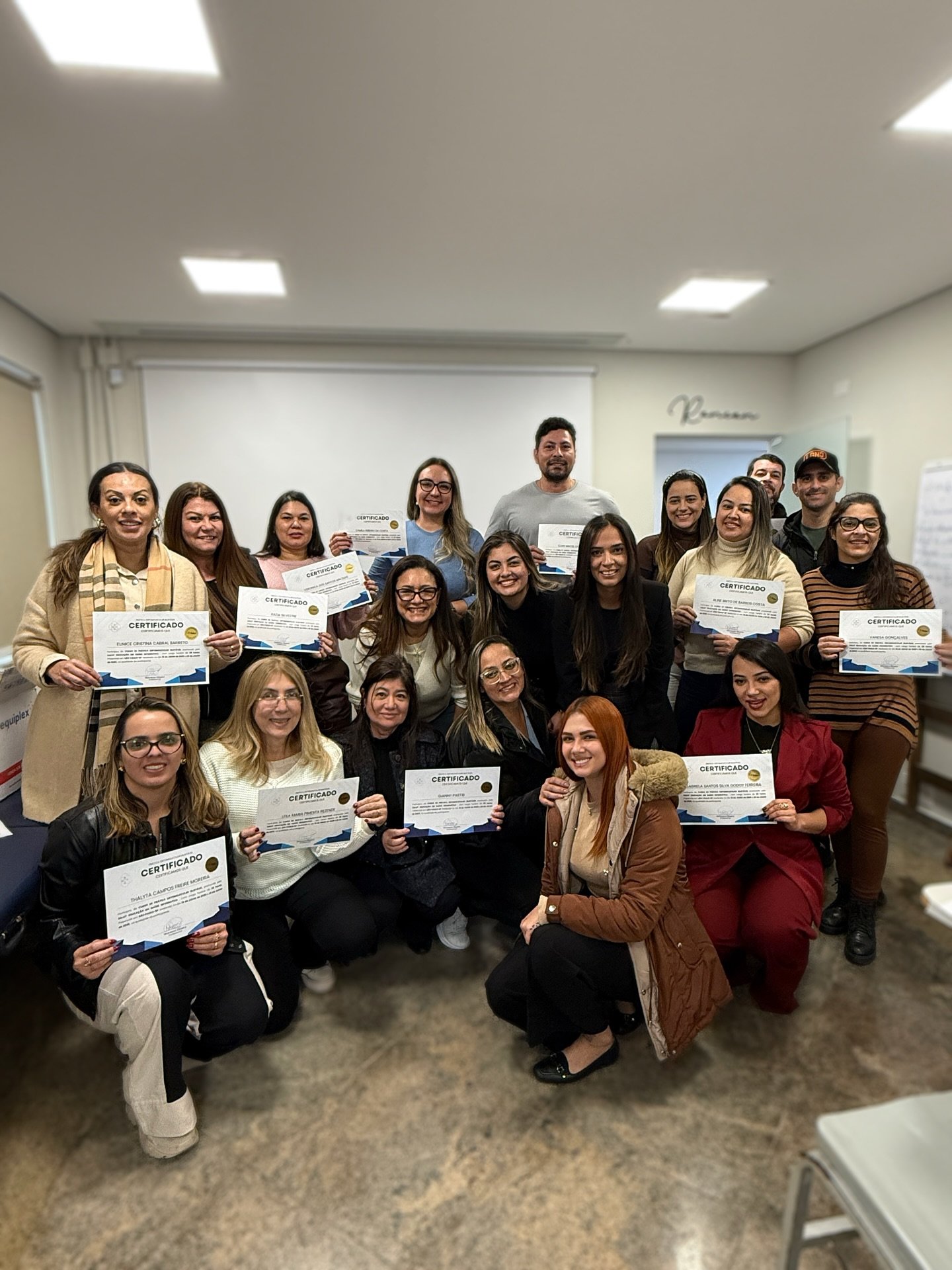Turma formada pela Salut segurando os certificados em sala de aula