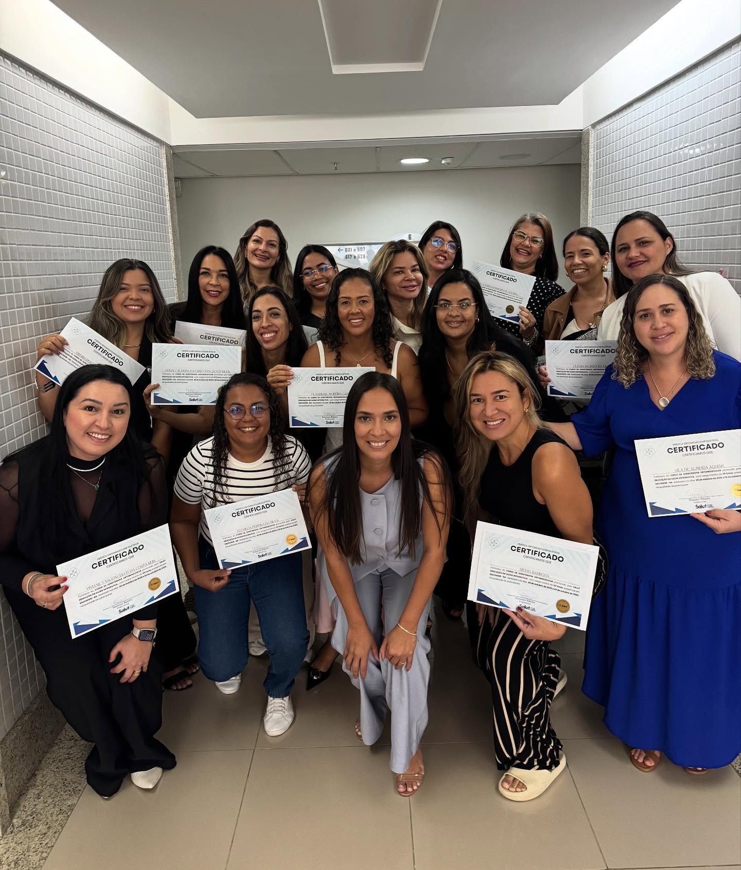 Turma de alunas da Salut com certificados no corredor da formação